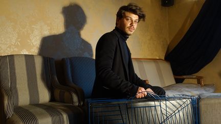 Le créateur de maroquinerie Hugo Matha pose avec sa grand malle en fil de métal bleu, janvier 2016 à Paris
 (Corinne Jeammet)