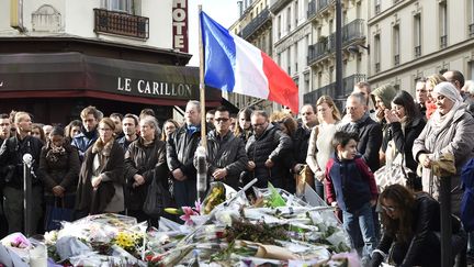 Des Parisiens rassemblés, le 16 novembre 2015, devant le Carillon, café visé trois jours plus tôt par une attaque terroriste. (ERIC FEFERBERG / AFP)