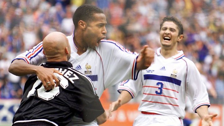 Thierry Henry se jette dans les bras de Fabien Barthez, sous les yeux de&nbsp;Bixente Lizarazu, apr&egrave;s la victoire de la France sur l'Italie, le 3 juillet 1998, &agrave; Saint-Denis. (GABRIEL BOUYS / AFP)