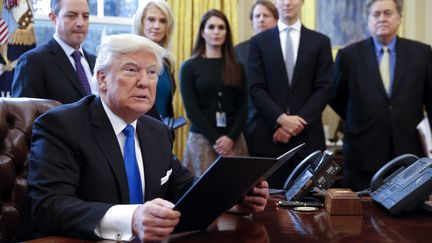 Le président américain Donald Trump, le 24 janvier 2017 dans le bureau ovale de la Maison Blanche, à Washington (Etats-Unis), avec des membres de son équipe. (SHAWN THEW / CNP / AFP)