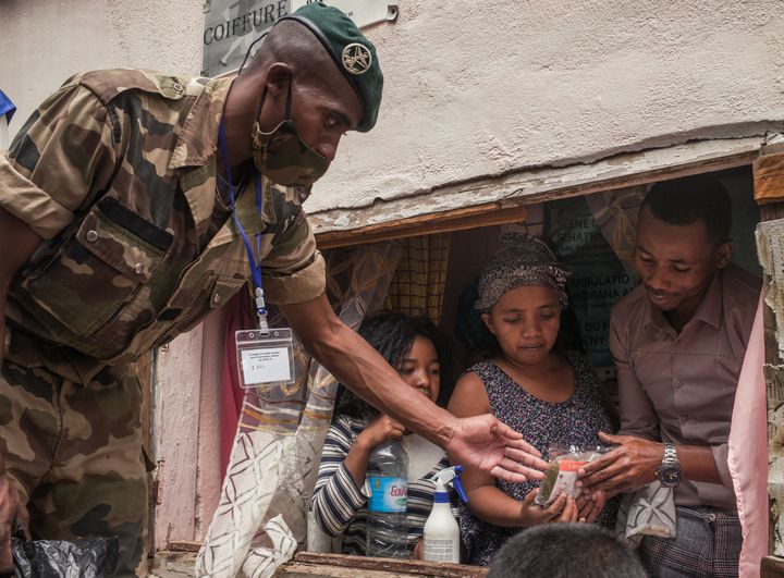 Des soldats de l'armée malgache distribuent des masques et des sachets d'herbes à infuser contre le coronavirus, le 22 avril 2020, dans le centre-ville d'Antananarivo. (RIJASOLO / AFP)