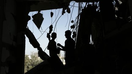 Des Palestiniens dans leur maison d&eacute;truite, dans la bande de Gaza; vendredi 1er ao&ucirc;t 2014. (MOHAMMED ABED / AFP)