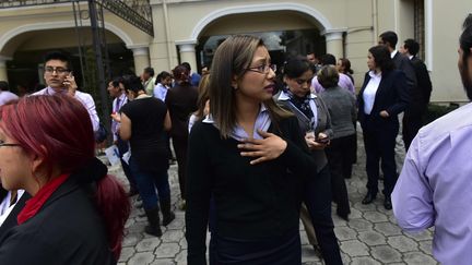 Des fonctionnaires sortent du ministère des Affaires étrangères à Quito (Equateur), le 18 mai 2016, après un nouveau séisme. (RODRIGO BUENDIA / AFP)