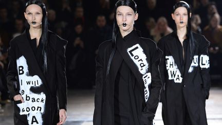 Chez Yohji Yamamoto, les silhouettes sont très longues et fluides, en noir et blanc. Elles s'accompagnent d'un maquillage noir, avec bouche en coeur et traits de crayon de part et d'autre.
 (BERTRAND GUAY / AFP)