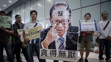 Les dockers brandissent des pancartes à l’effigie de Li Ka-shing, homme d’affaire milliardaire et président du groupe Watson,  numéro un mondial de la gestion de ports dans le monde.  (AFP PHOTO / Philippe Lopez)