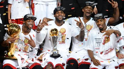 Dwyane Wade, LeBron James, Chris Bosh&nbsp;et&nbsp;Norris Cole, joueurs du&nbsp;Miami Heat, c&eacute;l&egrave;brent leur titre de champion NBA &agrave; Miami, en Floride (Etats-Unis), le 20 juin 2013. (GARRETT ELLWOOD / NBAE / GETTY IMAGES / AFP)