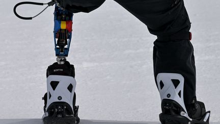 Engagé en snowboardcross (catégorie LL1), le Roumain Mihaita Papara a dévoilé une prothèse aux couleurs de son pays sur le Snow Park de Genting, le 6 mars 2022 aux Jeux paralympiques de Pékin.&nbsp; (MOHD RASFAN / AFP)