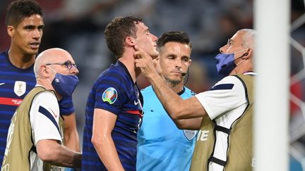 Benjamin Pavard a rapidement été examiné sur la pelouse par le staff médical de l'équipe de France après son choc avec Robin Gosens. (MATTHIAS HANGST / POOL)