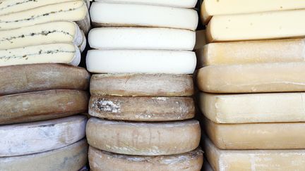 Des meules de fromage sur un marché, le 21 juin 2023. (GODONG / ROBERT HARDING RF / AFP)