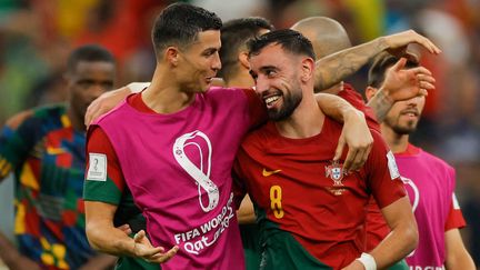 Les joueurs portugais Cristiano Ronaldo et Bruno Fernandes victorieux face à l'Uruguay, le 28 novembre 2022. (ODD ANDERSEN / AFP)