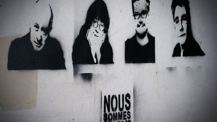 Les pochoirs de l'artiste fran&ccedil;ais Rob.Ink repr&eacute;sentant (de G &agrave; D), Wolinski, Cabu, Charb et Tignous sur un mur pr&egrave;s des locaux de l'hebdomadaire Charlie Hebdo &agrave; Paris, le 7 f&eacute;vrier 2015. (JOEL SAGET / AFP)