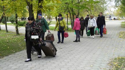 Des civils évacués de la ville de Kherson arrivent dans la ville voisine d'Oleshky après avoir traversé le fleuve Dnipro sur un bateau de passagers, le 25 octobre 2022.&nbsp; (STRINGER / AFP)