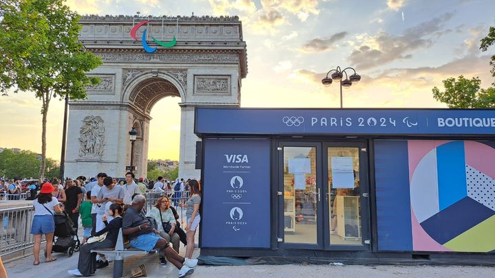 Juste devant l'Arc de Triomphe, à Paris, une pancarte indique que seules les cartes Visa sont autorisées à l'intérieur d'une boutique officielle des Jeux olympiques, le 29 juillet 2024. (RAPHAEL GODET / FRANCEINFO)