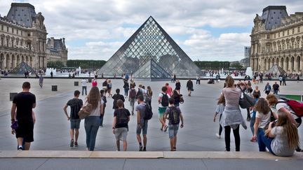 Des touristes devant la pyramide du musée du Louvre, à Paris, le 28 septembre 2016. (NICOLAS JOSE / HEMIS.FR / AFP)