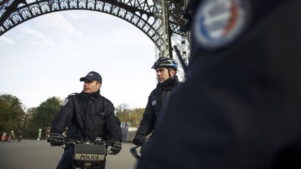 Des policiers patrouillent sous la tour Eiffel, le 19 novembre 2013, &agrave; Paris. (FRED DUFOUR / AFP)