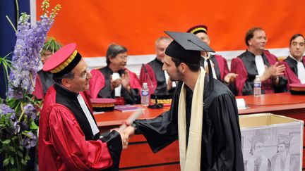 Un professeur de l'universit&eacute; Paris VI Pierre-et-Marie-Curie serre la main d'un &eacute;tudiant, lors de la c&eacute;r&eacute;monie de remise de son doctorat, le 13 juin 2009, &agrave; Paris. (MIGUEL MEDINA / AFP)