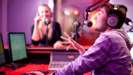 Un homme et une femme dans un studio radio. (ZERO CREATIVES / CULTURA CREATIVE / AFP)