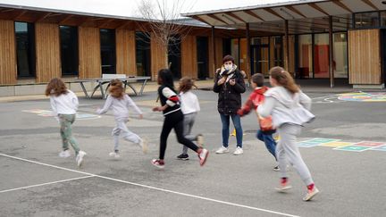 Des élèves d'une école primaire de Bruyères-le-Châtel (Essone) pratiquent le sport dans la cour, le 19 janvier 2021. (MYRIAM TIRLER / HANS LUCAS / AFP)