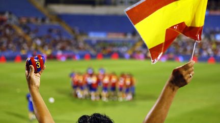 Un fan de foot brandit le drapeau espagnol et le maillot du FC Barcelone de Gerard Pique lors de l'entrainement jeudi, avant Espagne-Albanie. (MAXPPP)