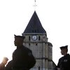 Des policiers devant l'église de Saint-Etienne-du-Rouvray (Seine-Maritime), le 27 juillet 2016. (CHARLY TRIBALLEAU / AFP)