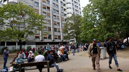 Des centaines de Syriens et d'Afghans patientent devant le Bureau des affaires sociales de Berlin (Allemagne), dans l'espoir de s'enregistrer, jeudi 3 septembre.&nbsp; (MEHMET KAMAN / ANADOLU AGENCY / AFP)