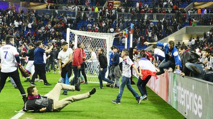 Des supporters enjambent les barrières et pénètrent sur la pelouse du Parc OL à Lyon, le 13 avril 2017. (RICHARD MOUILLAUD / MAXPPP)