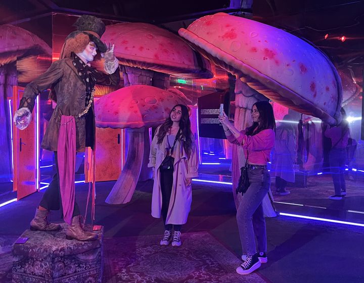 Entouré de champignons géants, le Chapelier fou salue les visiteuses dans une salle du Labyrinthe de Tim Burton. (LAURE NARLIAN / FRANCE INFO)