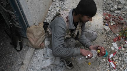 Un combattant pr&eacute;pare une boule de feu, &agrave; Deir Ezzor,dans le nord de la Syrie, le 10 janvier 2014. (AHMAD ABOUD / AFP)