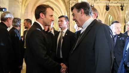 Emmanuel Macron sert la main de l'archevêque de Paris, lors de la conférence des évêques&nbsp;de France, au collège des Bernardins, à Paris. (LUDOVIC MARIN / POOL)