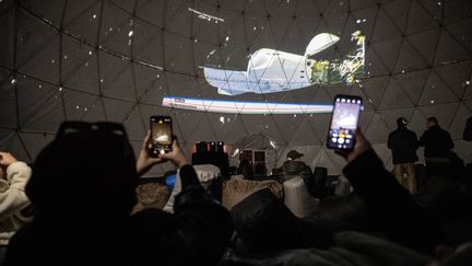 Des habitants d'Istanbul (Turquie) suivent l'arrimage à l'ISS de la capsule dans laquelle se trouve le premier Turc à participer à une mission spatiale, le 20 janvier 2024. (CEM TEKKESINOGLU / ANADOLU / AFP)