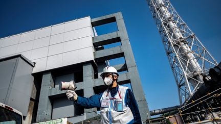 Un employé de la compagnie Tepco mesure le niveau de radioactivité à la centrale de Fukushima (Japon), le 21 février 2021. (PHILIP FONG / AFP)