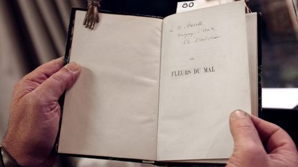 Un expemplaire de l'édition originale des "Fleurs du mal" de Charles Baudelaire dédicacé par l'auteur. (FRANCOIS GUILLOT / AFP)