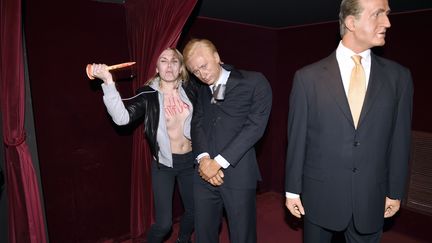 Iana Zhdanova, militante Femen, attaque la statue de cire de Vladimir Poutine, au musée Grévin, à Paris, le 5 juin 2014. (ERIC FEFERBERG / AFP)