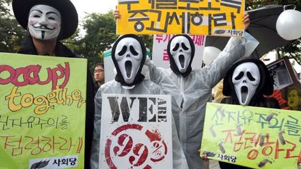 En Corée du Sud, les masques du film «Scream», mélangés aux masques de Guy Fawkes, prennent d'assaut Yeouido, le quartier d’affaire de Séoul. (AFP/PARK JI-HWAN )