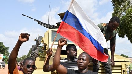 Des manifestants brandissant le drapeau russe lors de manifestations anti-France à Ouagadougou, capitale du Burkina Faso, le 4 octobre 2022. (ISSOUF SANOGO / AFP)