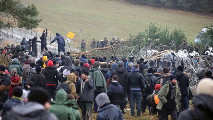 Des migrants massés à la frontière entre la Pologne et la Biélorussie, le 8 novembre 2021. (LEONID SHCHEGLOV / BELTA)