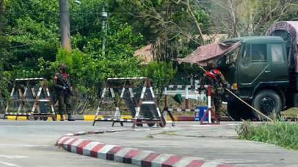 Des soldats birmans bloquent une route près du Parlement à Naypyidaw,&nbsp;le 14 mars 2021, alors que les manifestations contre le coup d'Etat militaire se poursuivent. (STR / AFP)