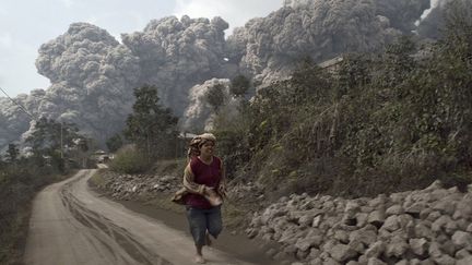 Une femme prend la fuite pendant une &eacute;ruption du mont Sinabung &agrave;&nbsp;Sigarang-Garang (Indon&eacute;sie), le 1er f&eacute;vrier 2014. (REUTERS)