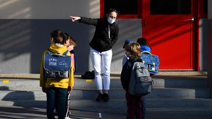 Des élèves dans une cour d'école à Paris, le 14 mai 2020.&nbsp; (FRANCK FIFE / AFP)