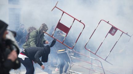 Des manifestants lancent des barrières lors d'un rassemblement contre la loi Travail à Nantes, le 31 mars 2016. (OLIVIER LANRIVAIN / MAXPPP)