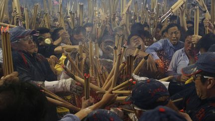 Des hommes se pressent pour planter un b&acirc;ton d'encens pour la nouvelle ann&eacute;e dans un temple &agrave; Singapour, le 31 janvier 2014. (EDGAR SU / REUTERS)