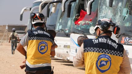 Des membres des Casques blancs syriens, lors d'une évacuation de civils des villages de Foua et Kafraya (Syrie), le 19 juillet 2018.  (AHMED RAHHAL / ANADOLU AGENCY / AFP)