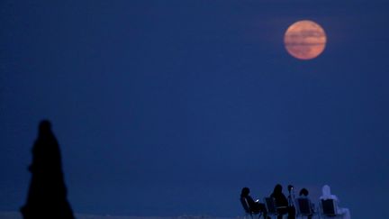 Des hommes observent la "super Lune" à Koweit City (Koweit), le 14 novembre 2016. (YASSER AL-ZAYYAT / AFP)