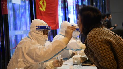 Un travailleur médical prélève des échantillons sur un écouvillon sur un site de la ville de Lanzhou, dans la province de Gansu, le 21 octobre 2021. (FAN PEISHEN / XINHUA)