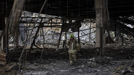 Un sauveteur dans les ruines du centre commercial de Krementchouk (Ukraine), le 29 juin 2022. (METIN AKTAS / ANADOLU AGENCY / AFP)