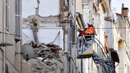 Des pompiers inspectent, le 8 novembre 2018, les décombres d'un immeuble effondré rue d'Aubagne, à Marseille. (GERARD JULIEN / AFP)