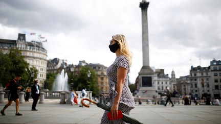 Une femme masquée dans les rues de Londres, à Trafalgar Square, le 21 août 2020.&nbsp; (HENRY NICHOLLS / REUTERS)