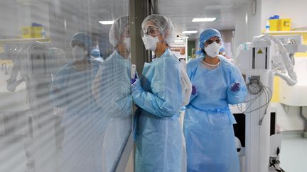 Deux infirmières attendent dans le couloir d'un service de détresse respiratoire où sont traités les malades atteints du Covid-19 à l'Hôpital Marseille Nord le 2 février 2021. (NICOLAS TUCAT / AFP)