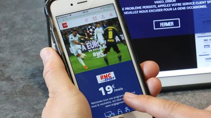 Une personne regarde la tablette avec le site RMC Sport.&nbsp; (JEAN-FRANÇOIS FREY / MAXPPP)