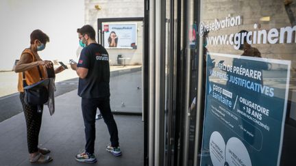 Contrôle des pass sanitaires devant les portes du cinéma CGR de Buxerolles (Vienne), le 21 juillet 2021. (MATHIEU HERDUIN / MAXPPP)